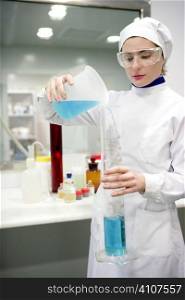 Chemical research laboratory, woman working, glass cylinder vase