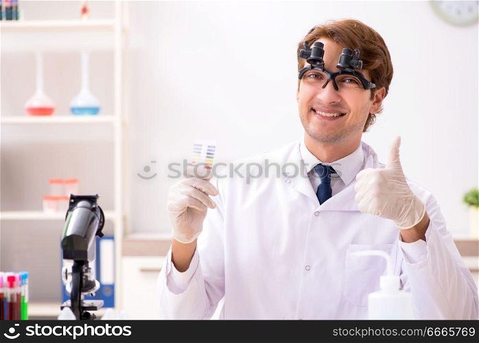 Chemist in the lab checking with ph strips