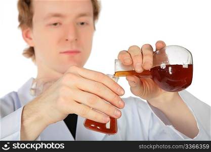 Chemist pours brown liquid from one flask in another