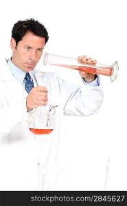 Chemist using a graduated cylinder and flask