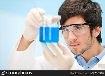 Chemistry experiment - scientist in laboratory, wear protective eyewear