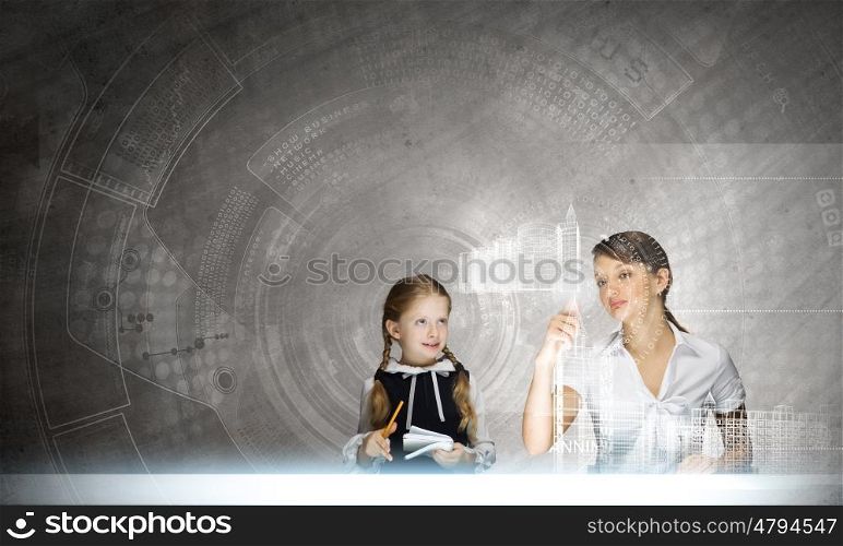 Chemistry lesson. Young teacher and her pupil at lesson looking at media screen