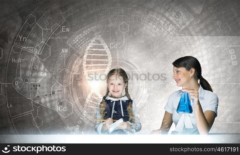 Chemistry lesson. Young teacher and her pupil doing tests at chemistry lesson