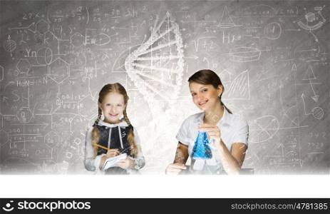 Chemistry lesson. Young teacher and her pupil doing tests at chemistry lesson