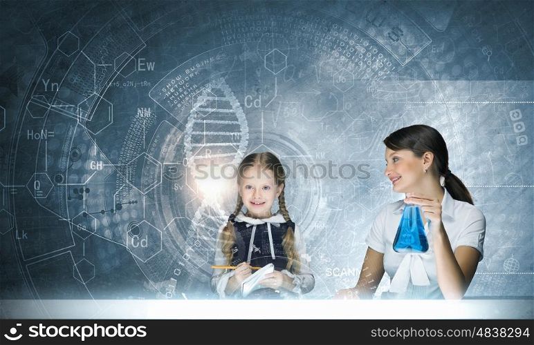 Chemistry lesson. Young teacher and school girl at chemistry lesson