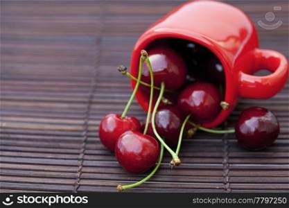cherry and cup on bamboo mat
