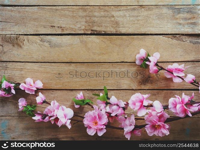 Cherry blossom and Artificial flowers on vintage wooden background with copy space.