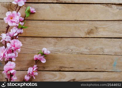 Cherry blossom and Artificial flowers on vintage wooden background with copy space.