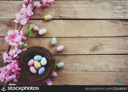 Cherry blossom Artificial flowers and easter egg in nest on vintage wooden background with copy space.