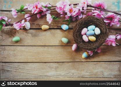 Cherry blossom Artificial flowers and easter egg in nest on vintage wooden background with copy space.