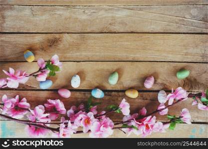 Cherry blossom Artificial flowers and easter egg on vintage wooden background with copy space.