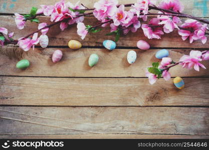 Cherry blossom Artificial flowers and easter egg on vintage wooden background with copy space.