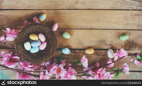 Cherry blossom flowers and easter egg in nest on vintage wooden background with copy space.