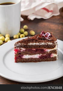 Cherry cake on white porcelain plate on wooden table