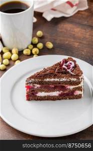 Cherry cake on white porcelain plate on wooden table