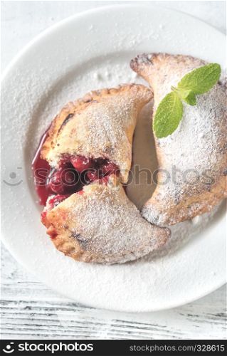 Cherry empanadas on the white plate