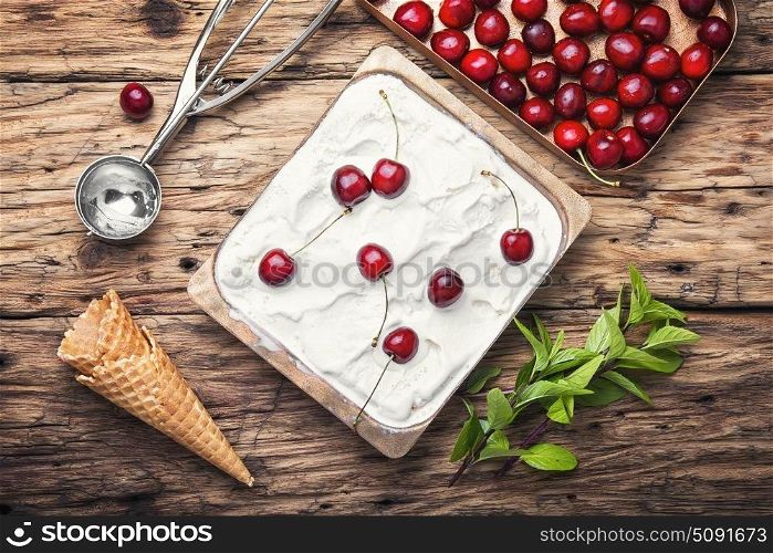 cherry ice cream in white bowl. vanilla ice cream in waffle cones and cherry berries