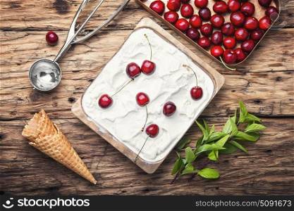 cherry ice cream in white bowl. vanilla ice cream in waffle cones and cherry berries