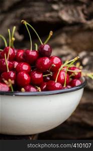 Cherry in a bowl on the wood background