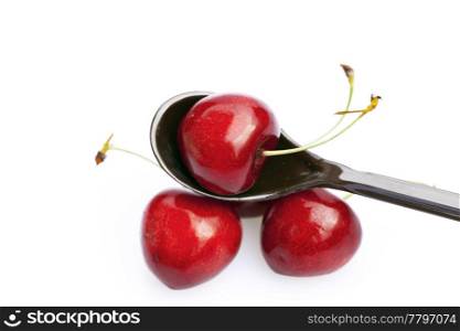 cherry in a spoon isolated on white