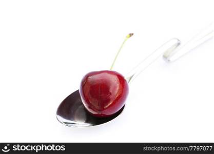 cherry in a spoon isolated on white