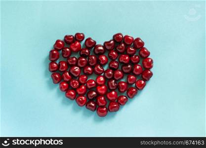 Cherry in shape of heart on blue background.. Cherry in shape of heart on blue background