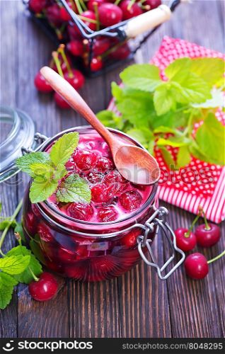 cherry jam and fresh berries on a table