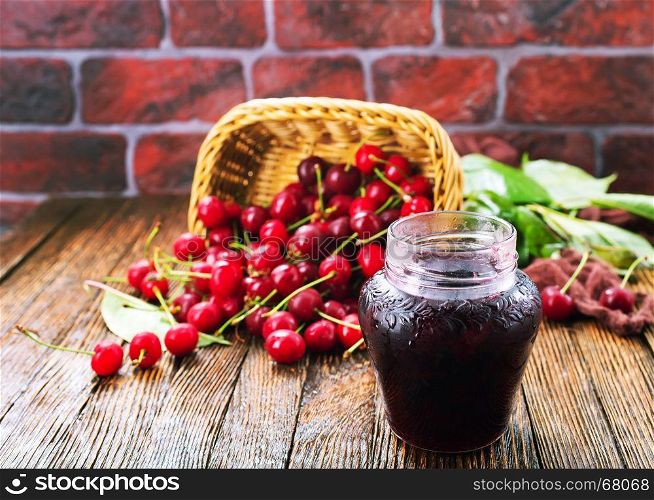 cherry jam in glass bank and on a table