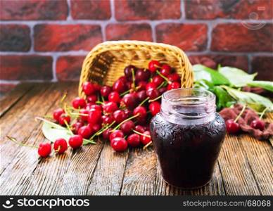 cherry jam in glass bank and on a table