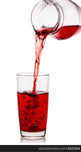 Cherry juice pours into a glass with a transparent decanter isolated on a white background. Cherry juice pours into glass with transparent decanter