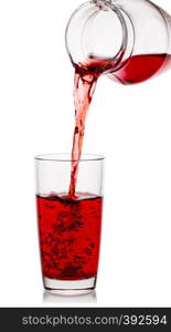 Cherry juice pours into a glass with a transparent decanter isolated on a white background. Cherry juice pours into glass with transparent decanter