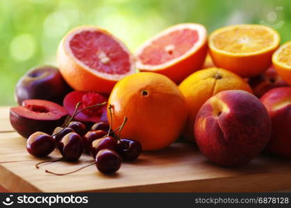 cherry, peaches and citric fruits on table