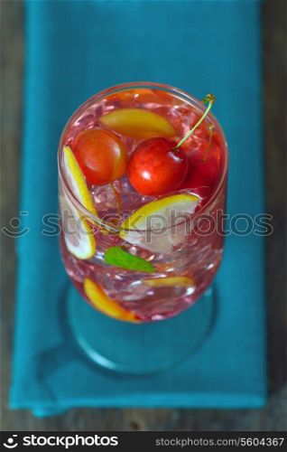 Cherry plum cocktail with ice, mint and lemon isolated. Above