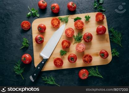 Cherry red tomatoes slices with knife on chopping board for making ketchup. Organic vegetables for making tasty full of vitamins salad. Vegetarian dish