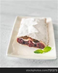 Cherry strudel with mint leaf on the white plate