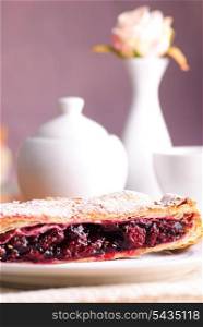 Cherry strudel with white dishes close up