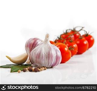 Cherry tomatoes and garlic on white background.