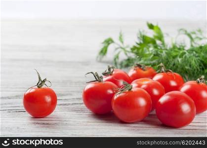 Cherry tomatoes and green dill on a wooden table