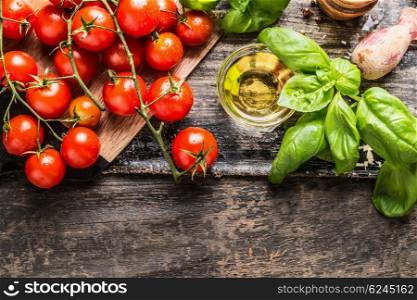 Cherry Tomatoes, basil and olive oil on wooden background, top view. Italian food cooking ingredients.