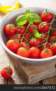 cherry tomatoes basil and olive oil over wooden background