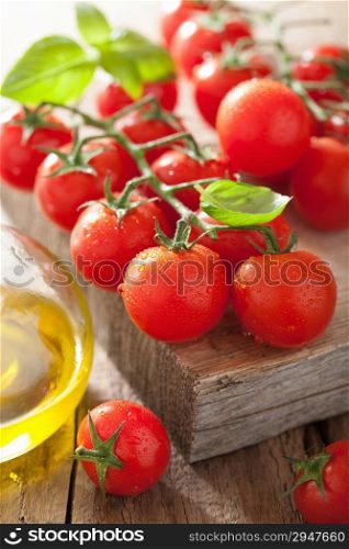 cherry tomatoes basil and olive oil over wooden background