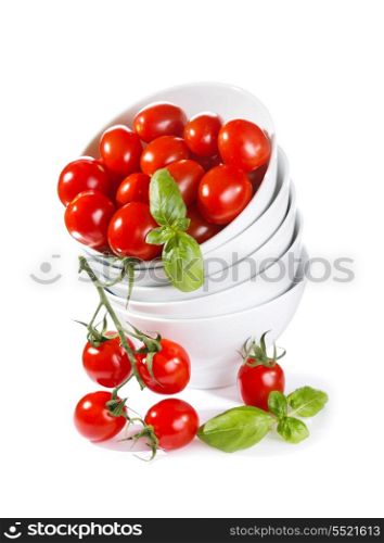 cherry tomatoes with green basil in a bowl on white background