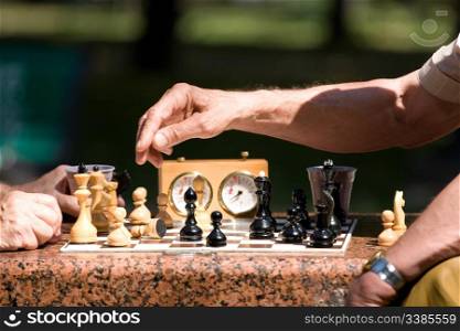 Chess board and hands of people in details