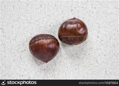 Chestnuts on craft paper. Autumn background. Top view.. Chestnuts on craft paper. Autumn background with sweet chestnuts.