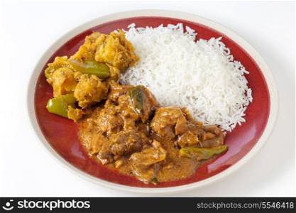 Chettinadu traditional Indian chicken bone-in curry, served with white rice and an aloo capsicum potato and bell pepper vegetable dish.