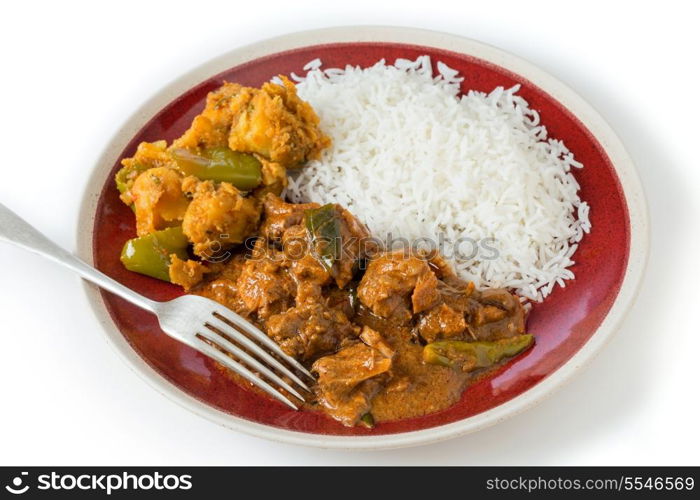 Chettinadu traditional Indian chicken bone-in curry, served with white rice and an aloo capsicum potato and bell pepper vegetable dish.