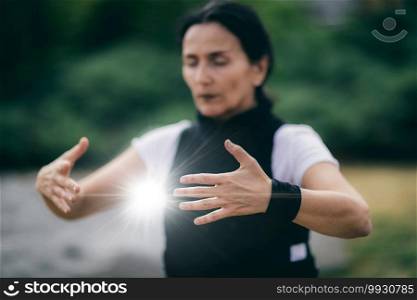 Chi Gong energy practice. Mature woman exercising in a park.. Qi Gong Training