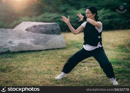 Chi Gong energy practice. Mature woman exercising in a park.. Woman Practicing Qi Gong