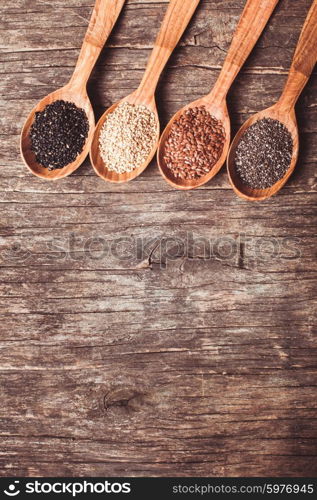 Chia and flax seeds, white and black sesame in wooden spoons. Copy space