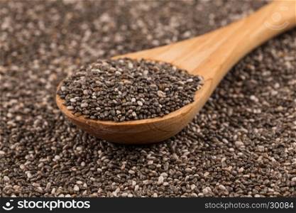 Chia seeds in a wooden spoon on chia background